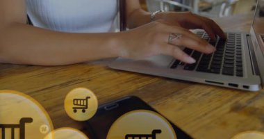 Daireler çizen alışveriş arabası ikonu animasyonu, dizüstü bilgisayarla çalışan beyaz bir kadının orta bölümü. Dijital bileşik, çoklu pozlama, perakende, satın alma, şekil, soyut ve teknoloji kavramı.