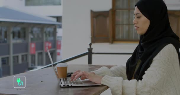Animation Flera Ikoner Över Biracial Kvinna Bär Hijab Arbetar Laptop — Stockvideo