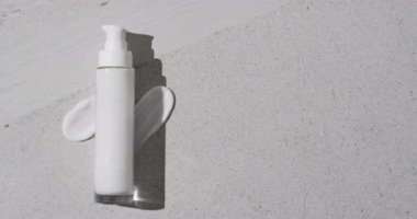 Beyaz arka planda fotokopi alanı olan güzellik ürünleri tüpü ve krem lekeleri videosu. Sağlık ve güzellik, makyaj, güzellik ürünleri, renk ve hareket kavramı.