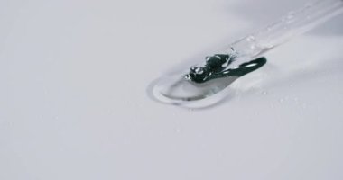 Makyaj pipeti ve beyaz arka planda fotokopi alanı olan serum damlalarının videosu. Sağlık ve güzellik, makyaj, güzellik ürünleri, renk ve hareket kavramı.