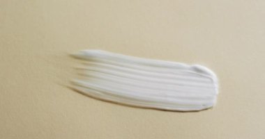 Sarı zemin üzerinde kopya alanı olan beyaz lekelerin videosu. Sağlık ve güzellik, makyaj, güzellik ürünleri, renk ve hareket kavramı.