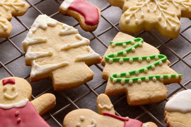 Gri arka planda fotokopi alanı olan dekore edilmiş Noel kurabiyelerini kapatın. Şeker, Noel, gelenek ve kutlama konsepti.