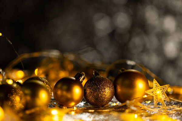 Gold christmas baubles with copy space on black background. Christmas, decorations, tradition and celebration concept.
