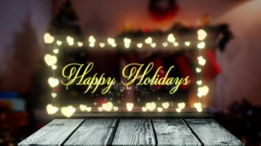 Mutlu bayram metinlerinin animasyonu peri ışıkları pankartıyla süslenmiş eve karşı ahşap tahta üzerine asılıyor. Noel şenliği ve tatil sezonu konsepti