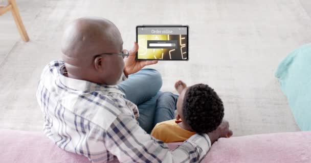 Afrikaanse Amerikaanse Grootvader Kleinzoon Met Behulp Van Tablet Online Winkelen — Stockvideo
