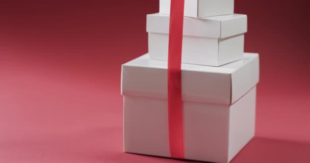 赤い背景のコピースペースを持つ赤いリボンのプレゼントのスタックのビデオ クリスマス お祝いのコンセプト — ストック動画