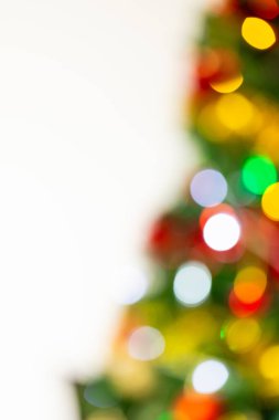 Beyaz arkaplanda fotokopi alanı olan, odak dışı noel ağacının dikey görüntüsü. Noel, dekorasyon, gelenek ve kutlama konsepti.