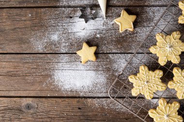 Noel kurabiyelerini un ve ahşap arka planda fotokopi alanı ile kapatın. Şeker, Noel, gelenek ve kutlama konsepti.