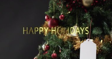 Süslü Noel ağacı ve boş hediye etiketi üzerine altın yazılı mutlu bayramlar mesajı. Noel, yeni yıl, gelenek, selamlama ve dijital olarak oluşturulan video kutlaması.
