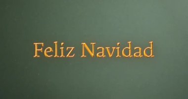 Feliz Navidad yeşil arka planda noel hediyeleri için turuncu mesaj atmış. Noel, gelenek, selamlar ve dijital olarak oluşturulan video kutlaması.