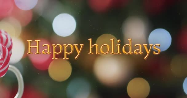 ボケのクリスマスライト上のキャンディー缶とオレンジのハッピーな休日のテキスト クリスマス お祝いのデジタル生成ビデオ — ストック動画