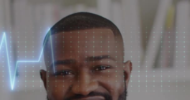 アフリカ系アメリカ人男性医師の顔面写真の半分に対する心拍数モニターのアニメーション 医療技術コンセプト — ストック動画