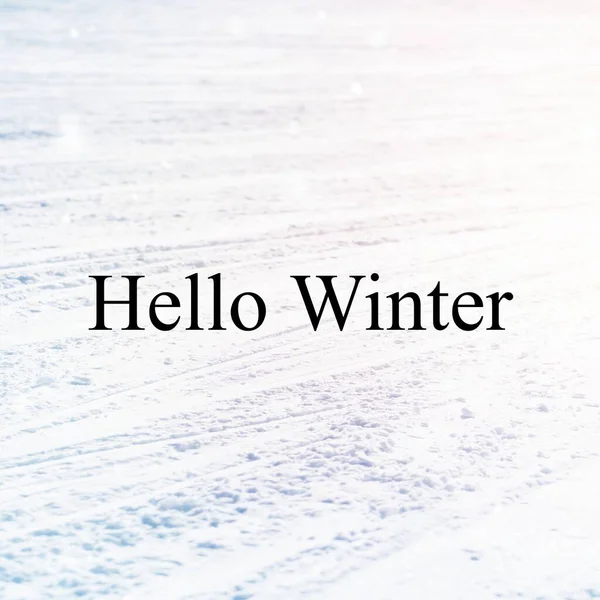 Hello winter text over tyre tracks in snow covered ground. Celebration of winter, nature, weather, greeting and christmas season, digitally generated image.