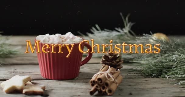 マシュマロ クッキー シナモンスティックのホットチョコレートの上にオレンジ色のメリークリスマステキスト クリスマス お祝いのデジタル生成ビデオ — ストック動画