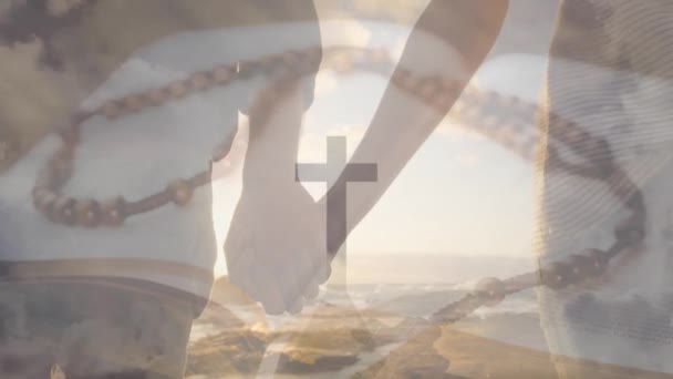 山上の十字架のアニメーション 聖書のロザリオ 多様なカップルのウォーキングホールディングの真ん中 デジタル複合 複数の露出 十字架 トータルネスコンセプト — ストック動画