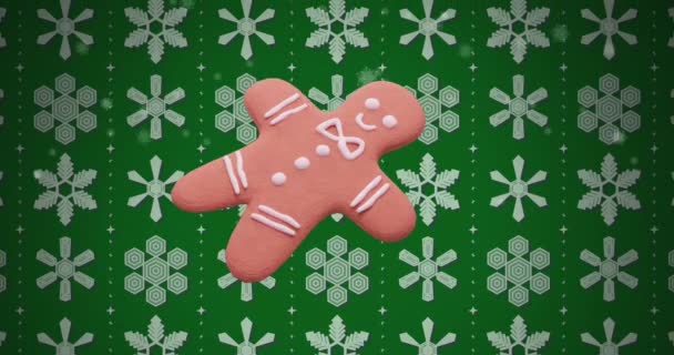 緑の背景に雪模様の上にジンジャーパンクッキーのアニメーション クリスマス お祝いのコンセプトデジタル生成ビデオ — ストック動画