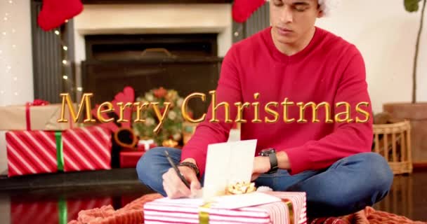 プレゼント付きのクリスマスカードを書いた白人男性の上の幸せな休日のテキストのアニメーション クリスマス お祝いのコンセプトデジタル生成ビデオ — ストック動画