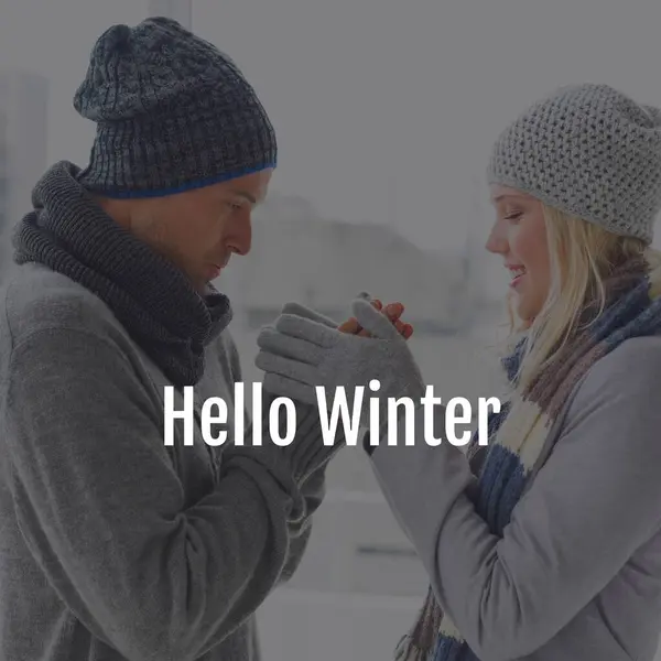 Composite of hello winter text over happy caucasian couple in winter scenery. Winter, christmas, seasons and celebration concept digitally generated image.