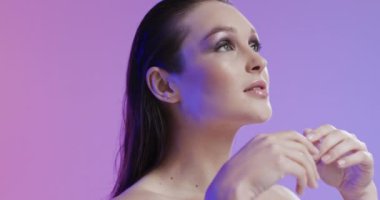 Kafkasyalı, kahverengi saçlı, makyajlı, yüzüne dokunan, fotokopi çeken, ağır çekim. Sağlık ve güzellik, makyaj, kadınlık kavramı, değiştirilmemiş..