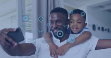 Afro-Amerikan baba ve oğlunun evde selfie çekmesine karşı veri işleme animasyonu. Babalık, aşk ve teknoloji kavramı
