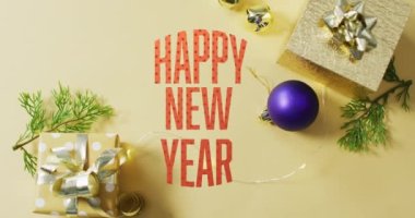 Noel ağacı, hediye kutuları ve ahşap masadaki mücevher üzerine neşeli ve parlak metin animasyonu. Dijital kompozit, çoklu pozlama, dekorasyon, tatil, olay ve kutlama konsepti.