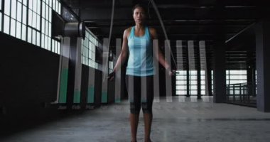 Spor salonunda hoplayan Afrikalı Amerikalı bir kadın üzerinde bar grafikleri olan aylık isimlerin animasyonu. Dijital bileşik, çoklu pozlama, rapor, iş, büyüme ve uygunluk kavramı.