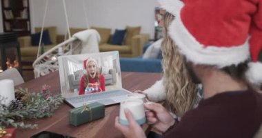 Kafkasyalı mutlu çift ve kız arkadaşının Noel 'de dizüstü bilgisayar görüntüsü alması, yavaş çekim. İletişim, aile, arkadaşlar, Noel, kutlama, birliktelik, gelenek ve yaşam tarzı, değiştirilmemiş.