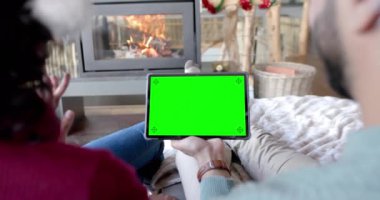 Mutlu çift, yeşil ekranlı, yavaş çekimde noel tableti görüntülü konuşma yapıyorlar. İletişim, aile, arkadaşlar, Noel, kutlama, birliktelik, gelenek ve yaşam tarzı, değiştirilmemiş.