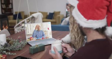 Kafkasyalı mutlu çift ve son sınıf erkek arkadaşı Noel 'de bilgisayar başında yavaş çekimde görüşüyorlar. İletişim, aile, arkadaşlar, Noel, kutlama, birliktelik, gelenek ve yaşam tarzı, değiştirilmemiş.