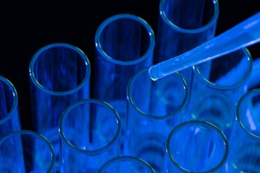 Laboratuvar test tüplerini ve mavi arka planda fotokopi alanı olan pipetleri kapatın. Laboratuvar, bilim, araştırma ve kimya konsepti.