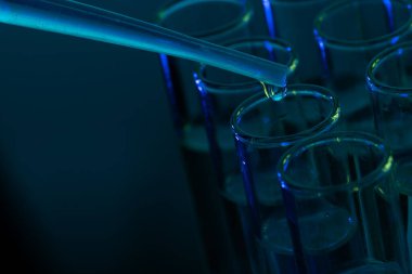 Laboratuvar test tüplerini ve mavi arka planda fotokopi alanı olan pipetleri kapatın. Laboratuvar, bilim, araştırma ve kimya konsepti.