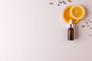 Şişeyi pipetli, portakallı ve beyaz arka planda kopya alanı olan tohumlarla kapat. Sağlık ve güzellik, güzellik ürünü, makyaj ve renk konsepti.
