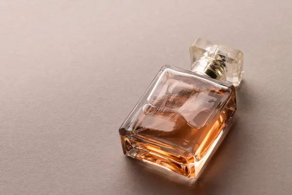 Close up of beauty product perfume bottle with copy space on brown background. Health and beauty, beauty product, make up and colour concept.