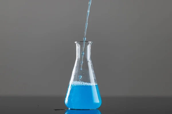 Close Van Laboratoriumbekerglas Met Blauwe Vloeistof Kopieer Ruimte Grijze Achtergrond — Stockfoto