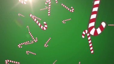 Yeşil arka planda düşen noel şeker kamışlarının animasyonu. Noel, kış, kutlama ve geleneksel konsept dijital olarak oluşturulmuş video.