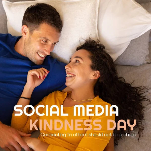 ソーシャルメディアの優しさの日テキストと幸せな慎重な若いカップルが自宅でベッドに横たわっています 他の人とつながることは 振る舞い 一緒に サポート グローバルなコミュニケーション 促進であるべきではありません — ストック写真