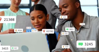 Bildirim simgelerinin birleşimi ve dizüstü bilgisayarda tartışan çeşitli meslektaşlar üzerinde değişen numaralar. Takım çalışması, teknoloji, iş, ofis, mobil uygulamalar, sosyal medya kavramı.