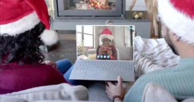 Mutlu çift ve erkek arkadaş, yılbaşı dizüstü bilgisayarlarını yavaş çekimde izliyorlar. İletişim, aile, arkadaşlar, Noel, kutlama, birliktelik, gelenek ve yaşam tarzı, değiştirilmemiş.