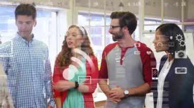 Çeşitli bilgisayar simgelerinin animasyonu ofiste ayakta duran ve konuşan çeşitli meslektaşlar üzerinde. Dijital bileşim, iş dünyası, takım çalışması, dizüstü bilgisayar, grafik, kamera, ayarlar, gülümseme ve iletişim.