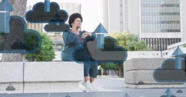 Şehirde akıllı telefon kullanan Afro-Amerikan kadının üzerindeki bulut ve ok simgelerinin canlandırılması. Küresel bulut hesaplaması, bağlantılar, ağlar, iş ve dijital arayüz kavramı dijital olarak oluşturulmuş video.