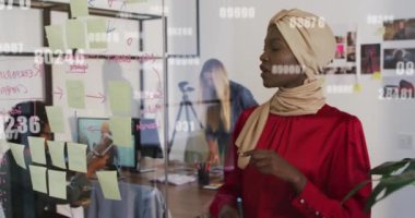 Ofisteki cam panoya not yapıştıran Afro-Amerikan vatandaşlarının numaralarını değiştirme animasyonu. Bilgisayar arayüzü ve iş teknolojisi kavramı