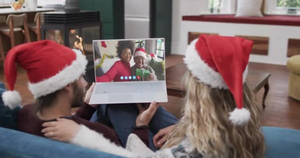 一对快乐多样的夫妇 母女都有圣诞节的手提电脑视频通话 动作缓慢 圣诞节 庆祝活动 传统和生活方式 — 图库视频影像