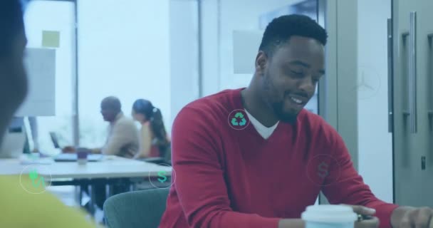 オフィスの机で議論するアフリカ系アメリカ人の同僚を巡る円のアイコンのアニメーション デジタル複合 複数の露出 リサイクル チームワークのコンセプト — ストック動画