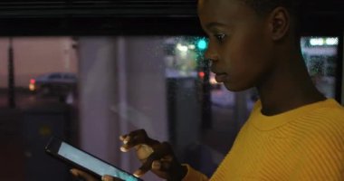 Afro-Amerikan kız otobüste dijital tablette kaydırma yaparken bildirilen barların animasyonu. Dijital bileşik, çoklu pozlama, çocukluk, sosyal medya anımsatıcı, ulaşım ve teknoloji.