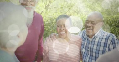 Bahçede gülümseyen yaşlı insanlar üzerinde ışık lekelerinin canlandırılması. Mutluluk, kıdemli yaşam tarzı, aktif yaşam tarzı ve dijital olarak oluşturulmuş emeklilik konsepti.