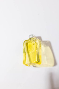 Sudaki güzellik ürünü şişesinin dikey görüntüsü ve beyaz arka planda fotokopi alanı var. Sağlık ve güzellik, makyaj ve güzellik konsepti.