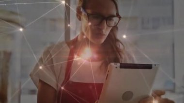 Tablet kullanan beyaz iş kadını üzerindeki ışık noktalarıyla olan bağlantıların animasyonu. Küresel bağlantılar, iş, iletişim ve dijital arayüz kavramı dijital olarak oluşturulmuş video.