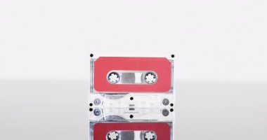 Kırmızı etiketli retro kaset ve beyaz arkaplanda kopya alanı olan yansıma videosu. Retro, nostalji, vintage, müzik ve bant kayıt kavramı.