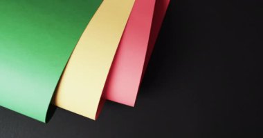 Siyah arkaplanda kopya alanı olan kırmızı, sarı ve yeşil kağıtların videosu. Siyah tarih ayı, farkındalık ve kültür konsepti.