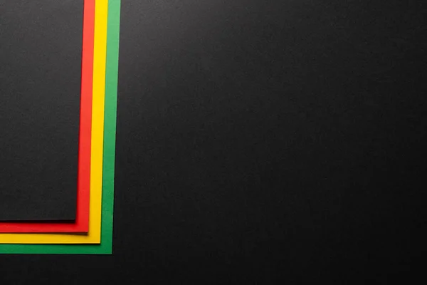 Green, yellow and red papers with copy space on black background. Black history month, africa, black culture and hsitory concept.